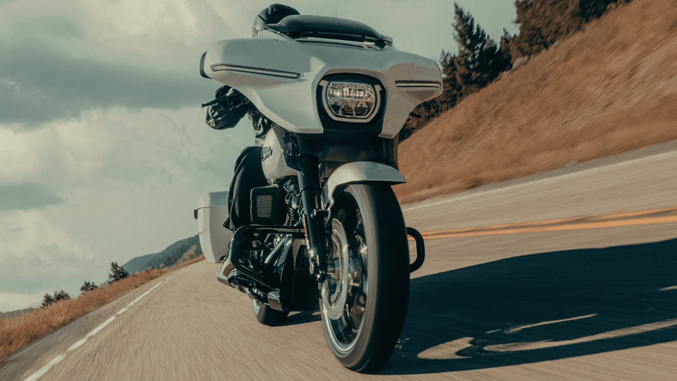 A rider on a 2025 Harley-Davidson® Road Glide® motorcycle cruising a highway near Orlando, FL, highlighting the thrill of the ride. Available at Space Coast Harley-Davidson® 