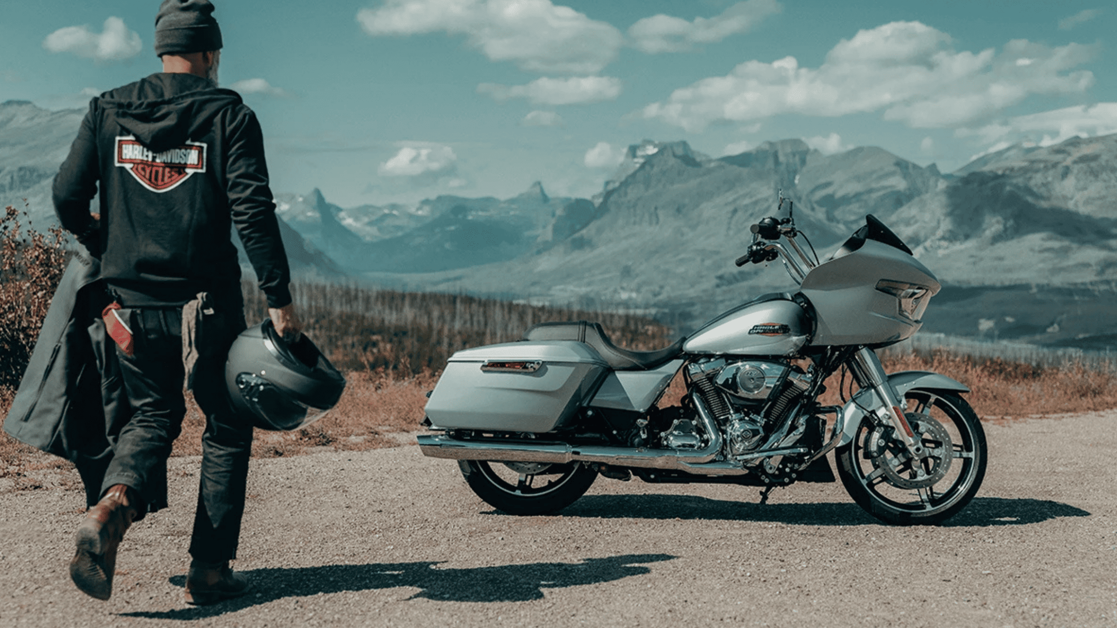 A man walks beside a 2025 Harley-Davidson® Road Glide® on a road near Orlando, FL, showcasing its sl…