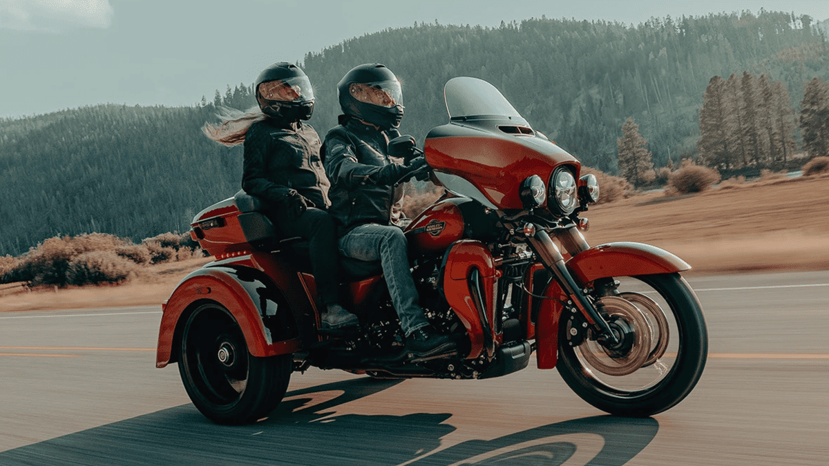 2025 Harley-Davidson® Tri Glide® Ultra with two riders cruising through scenic highway near Sanford, FL